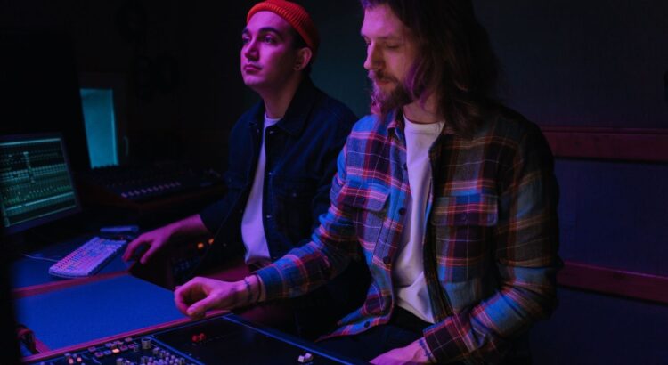 Zwei Musiker arbeiten an einem Mischpult im Tonstudio