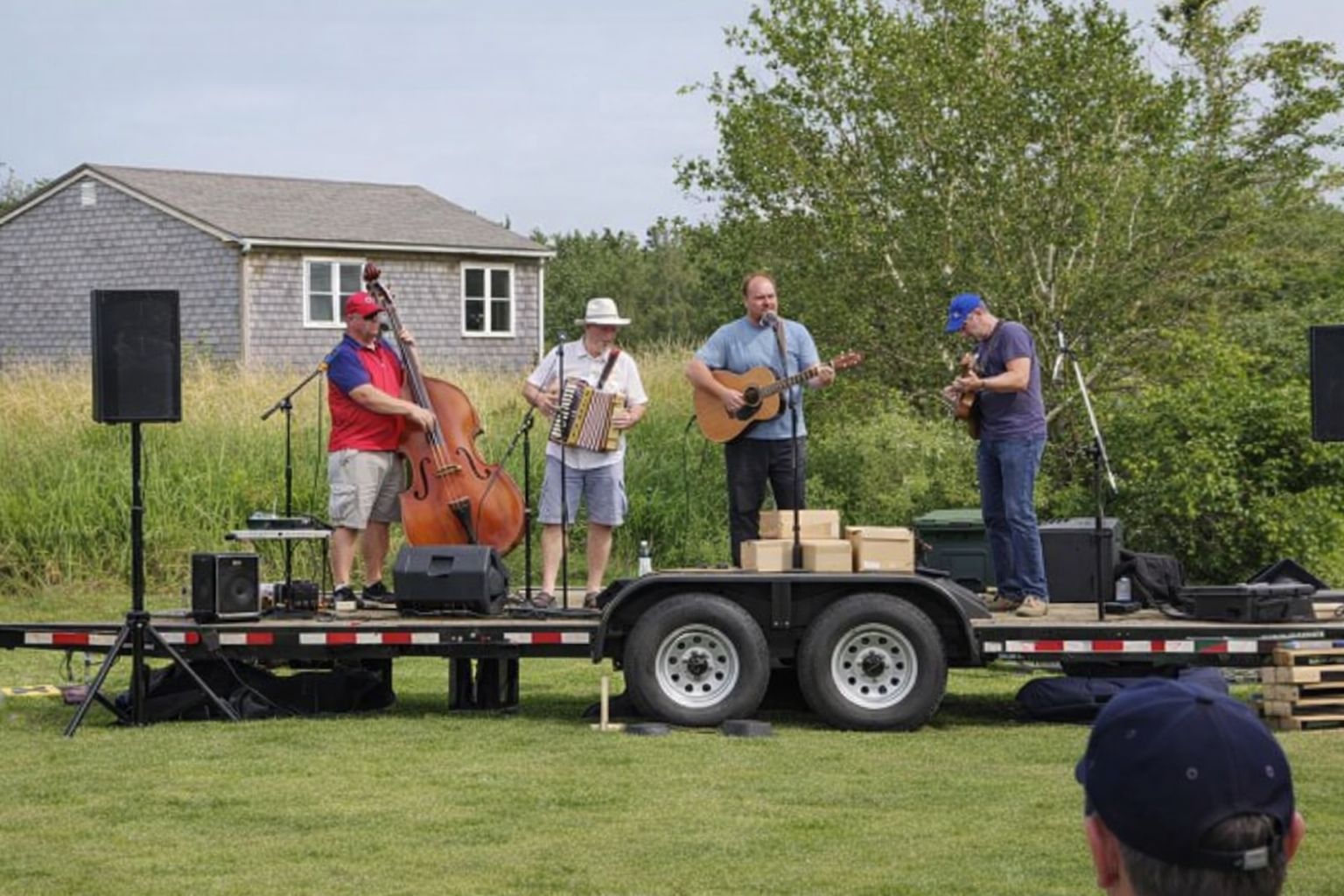 Vierköpfige Band spielt ein Live-Konzert auf einem PKW-Anhänger als mobile Bühne.